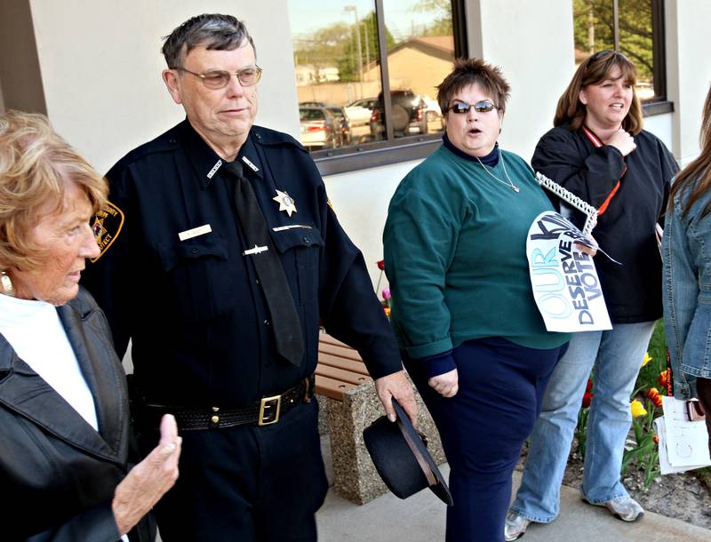 Beck Diefenbach  -  bdiefenbach@daily-chronicle.com

Lisa Wilcox (second from right), of DeKalb. voices her disapproval of Pollution Control Facility Committee member Marlene Allen (far left) as she exits with Sheriff Roger Scott, second from left, following the board's approval of the landfill expansion at the Legislative Center in Sycamore, Ill., on Tuesday April 27, 2010.