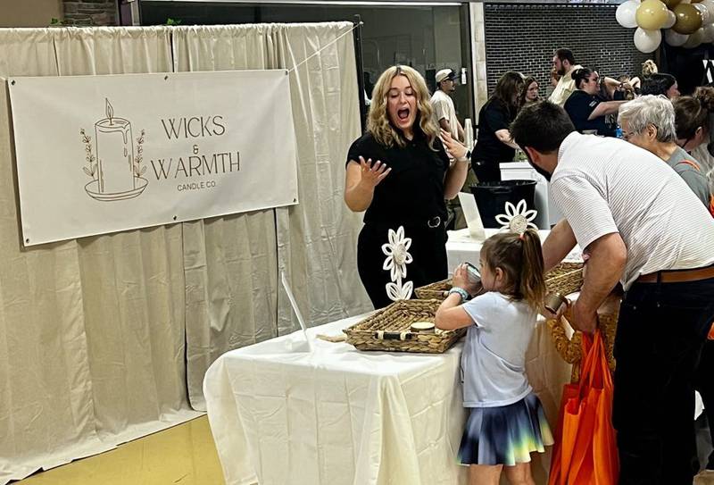 Polo Community High School senior Alayna Young greets customers at her business, Wicks & Warmth Candle Co., in Sterling's Northland Mall at the Whiteside Area Career Center's CEO program student trade show on April 23, 2025.