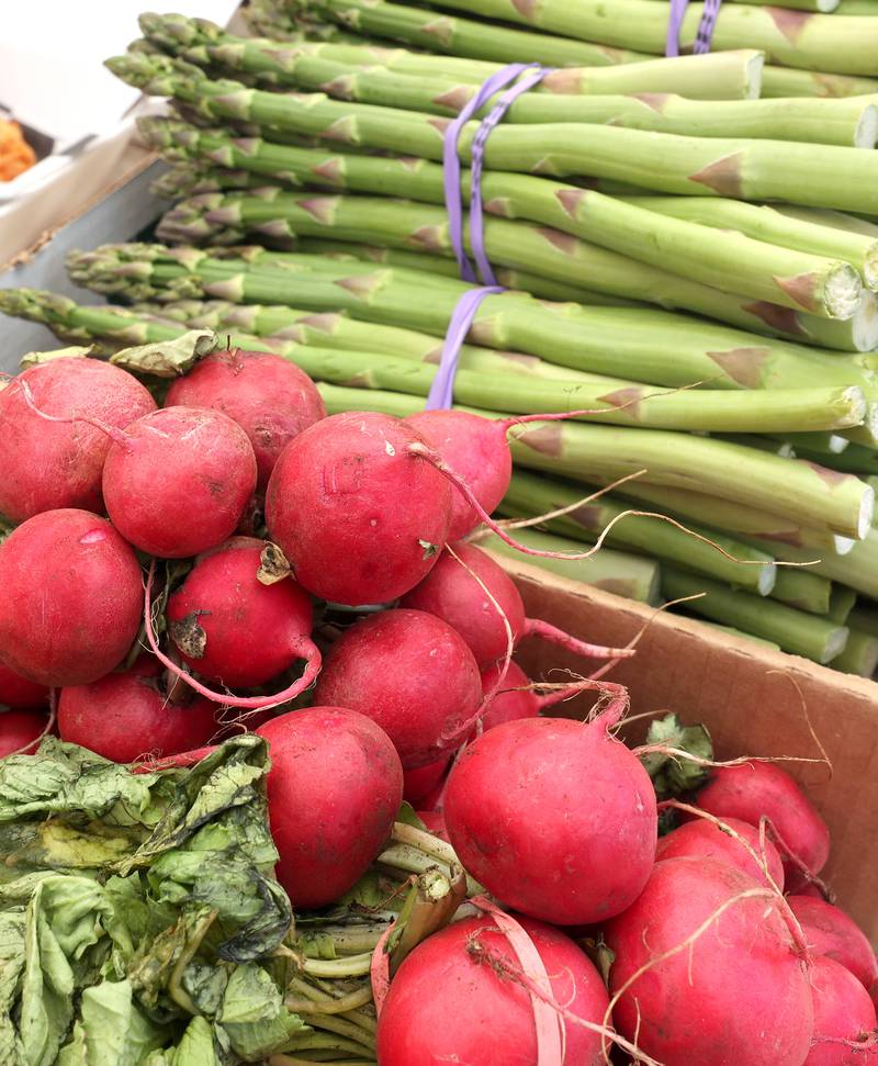 Radishes and asparagus at the Theis Farm Market booth Thursday, June 2, 2022, during the first DeKalb Farmers Market of the season at Van Buer Plaza in Downtown DeKalb.