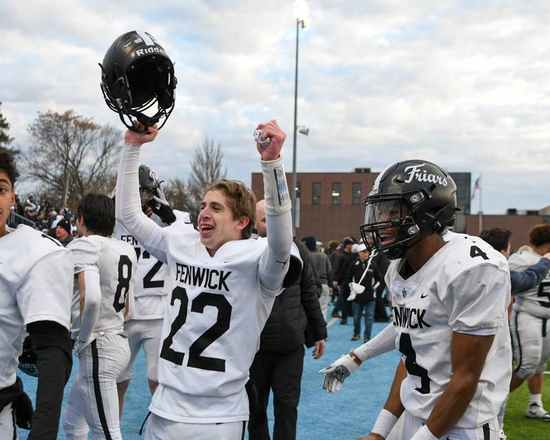 Fenwick's Topher Polston (22) and teammate Raphiel Stewart (4) celebrate while joining other teammates after beating Nazareth Academy in the 6A semifinals game on Saturday Nov. 22, 2025, held at Nazareth Academy High School in La Grange Park.