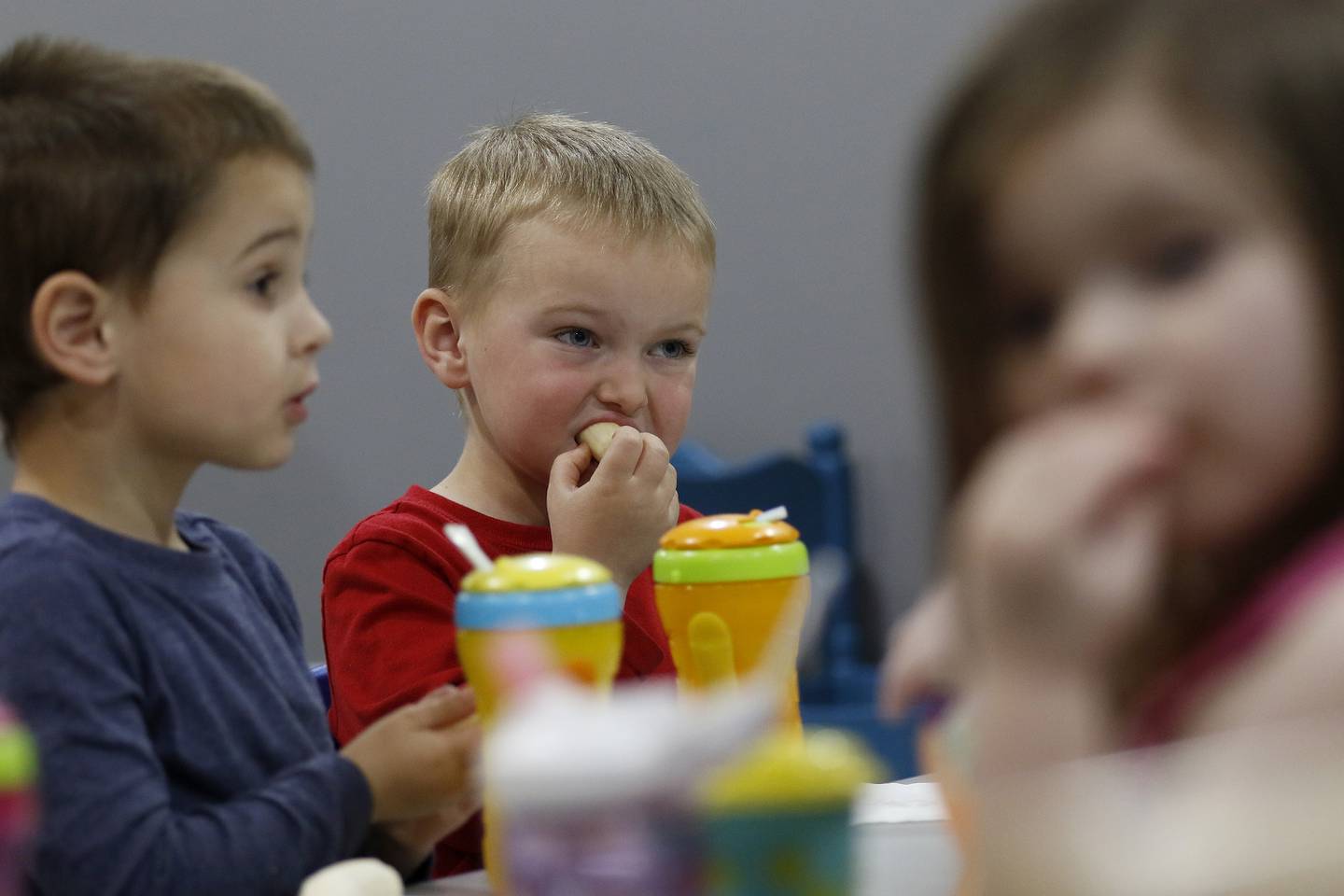 From left: Easton Bellusci, Austin Borris, ad Mia Famolaro enjoy a bite during snack time at Little Hands Home Daycare and Preschool on Friday, April 30, 2021, in Huntley.