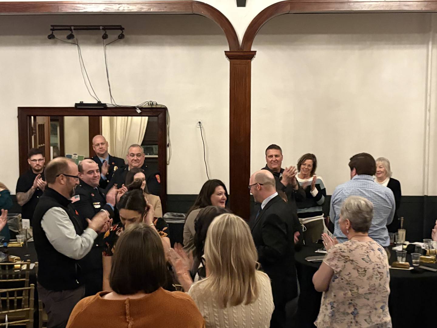 Streator Chamber of Commerce Executive Director Derek Barichello congratulates Streator Mayor Tara Bedei after presenting her with the Maxine Wargo Award during the chamber’s 112th annual dinner Monday, March 9, 2026, as attendees surround them, giving a round of applause.