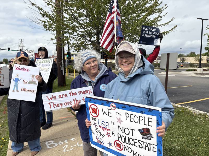 Protestors hold up signs during a May 1 protest in McHenry Friday May 1, 2026.