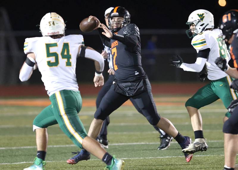 DeKalb's Adrien McVicar looks for a receiver as Waubonsie Valley's Jay Keeley applies pressure during their game against Thursday, Oct. 20, 2022, at DeKalb High School.