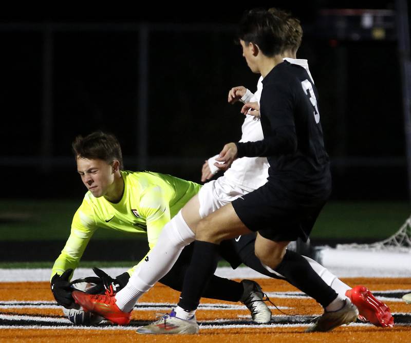McHenry's Auggie Arnold  grabs the ball of the foot of Huntley's Liam Caddick during a Fox Valley Conference boys soccer match on Thursday, Oct. 9, 2025, at McCracken Field in McHenry.