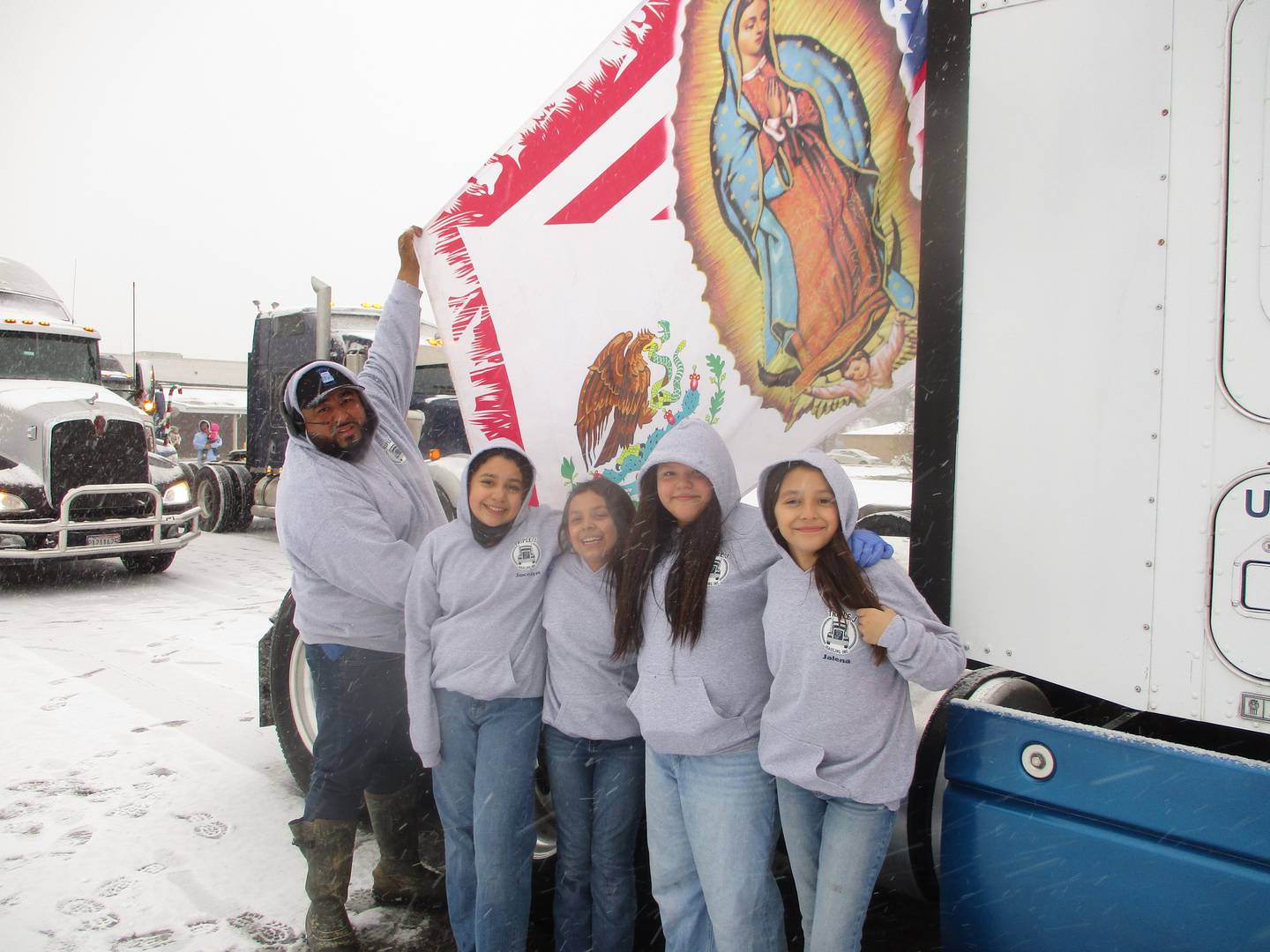 Alfonso Duenez (far left) is joined by his daughters and one of their cousins as he prepares a flag for his truck before a trucker pilgrimage from Joliet. Pictured with Duenez are (from left) Jocelyn Fuentes, Jazmine Fuentes, Karoline Aries and Jalena Fuentes.