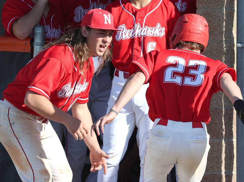 Naperville Central's Daniel Nussbaum (left) greets Josh Burner after he scored a run during their game against DeKalb Tuesday, April 30, 2024, at DeKalb High School.