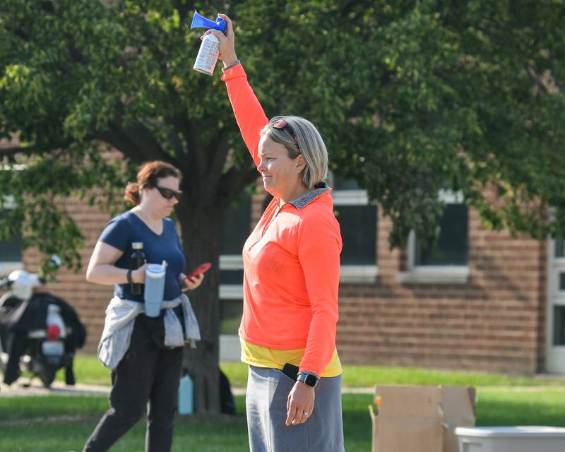 CASA board member Rita Johnson sounds the air horn at the start of the run on Saturday, June 7, 2025, during the CASA DeKalb County 5K Color Run held at the Sycamore Middle School.