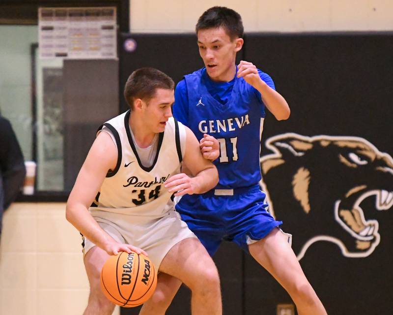 Glenbard North's Matt Melch (34) drives to the lane and makes a basket while being defended by Geneva's Kyle Suger (11) during the game on Tuesday Jan. 6, 2025, held at Glenbard North High School.