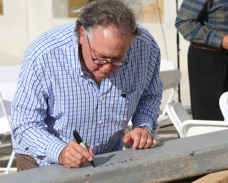 Ollies Bargain Outlet CEO John Swyherg signs "we are Ollies" on a steel beam that will be moved in place during a construction milestone at the new Ollie's distribution center on Tuesday, Sept. 26, 2023 in Princeton.