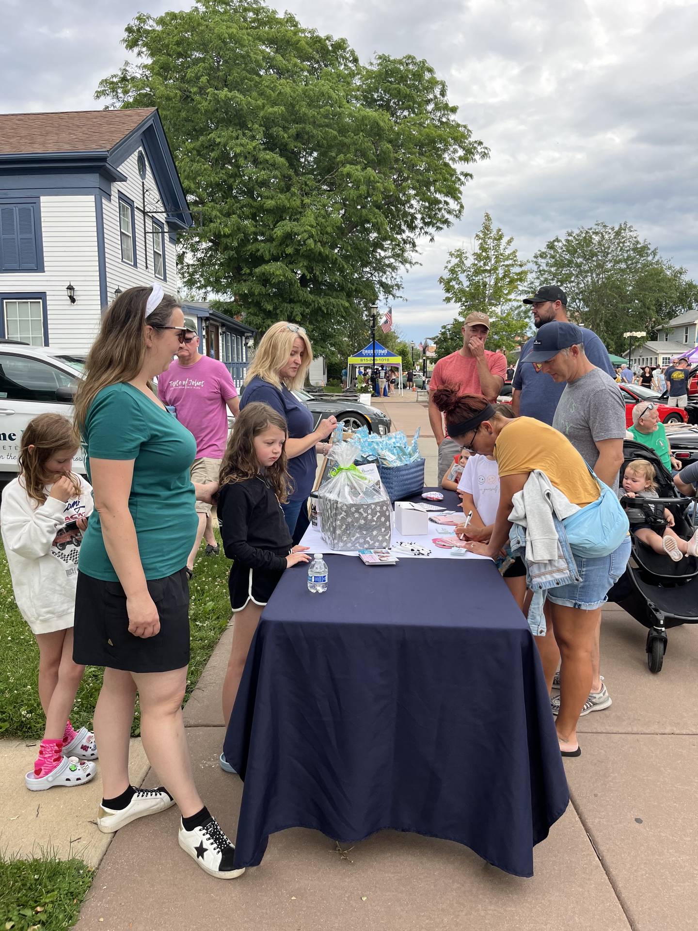 Members of staff at The Welcome Waggin, a house call veterinary service in Plainfield, meet and greet visitors to their table at the Plainfield Cruise Night on Lockport Street on June 11, 2024.