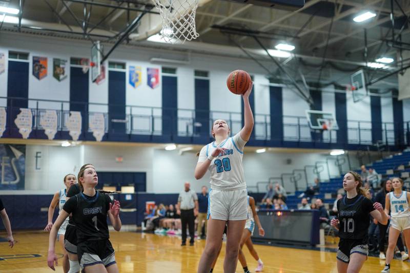 Downers Grove South's Megan Ganschow (20) shoots the ball in the post off of a backdoor cut against Oswego East's Aubrey Lamberti (1) during a 4A Oswego East Regional semifinal girls basketball game at Oswego East High School on Monday, Feb 12, 2024.