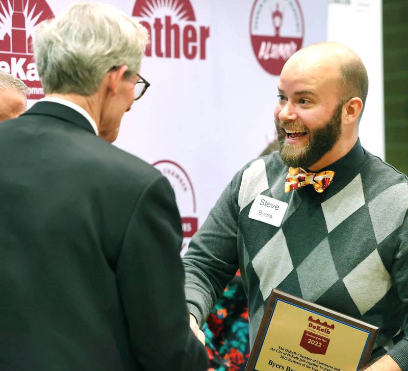 Steve Byers, co-owner of Byers Brewing Company, is congratulated by DeKalb City Manager Bill Nicklas after being announced as the 2022 Business of the Year Thursday, Feb. 9, 2023, during the DeKalb Chamber of Commerce’s Annual Celebration Dinner in the Barsema Alumni and Visitors Center at Northern Illinois University.