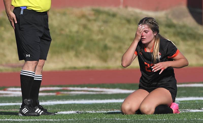 Libertyville’s Maddy Kopala holds her head after colliding with teammate Pru Babat in the IHSA girls state soccer semifinal game against Barrington at North Central College in Naperville on Friday, June 2, 2023.