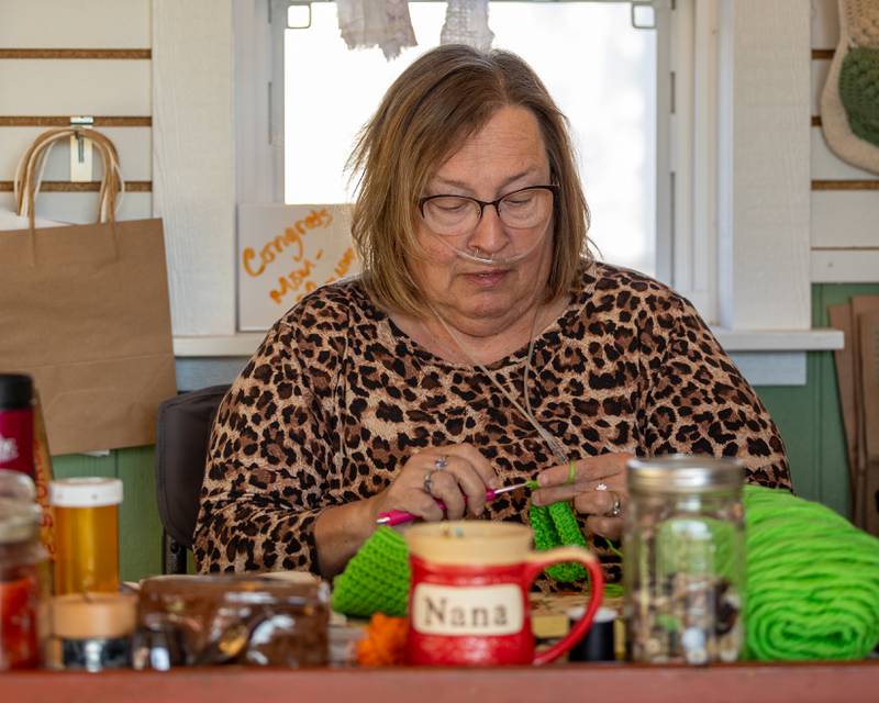 Cathy Wyse crochets at the annual Witches Walk on Friday, Oct. 17, 2025, at the Market on Mill in Utica.