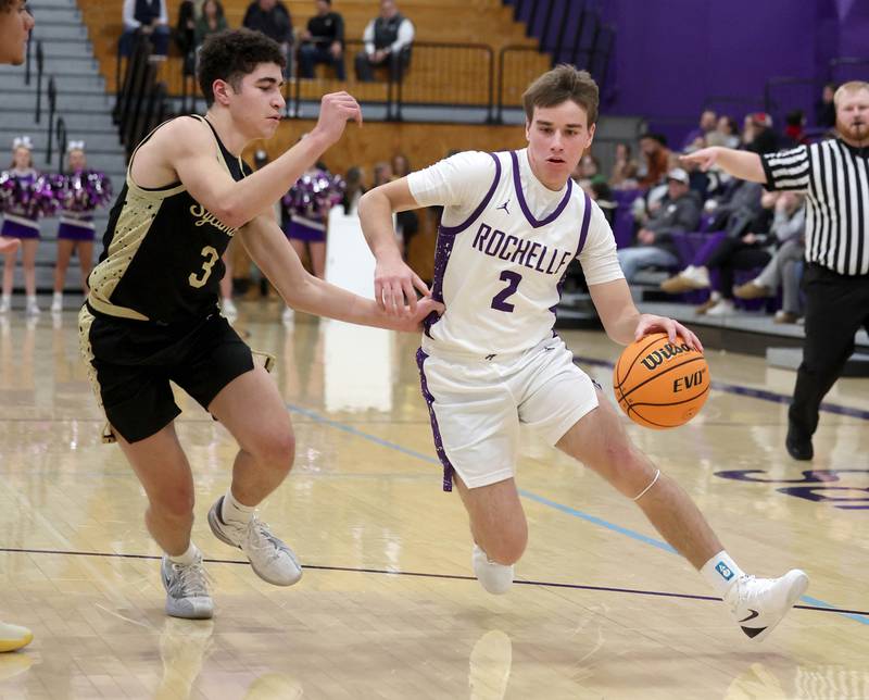 Rochelle's Van Gerber drives by Sycamore's Marcus Johnson Friday, Dec. 5, 2025, during their game at Rochelle High School.