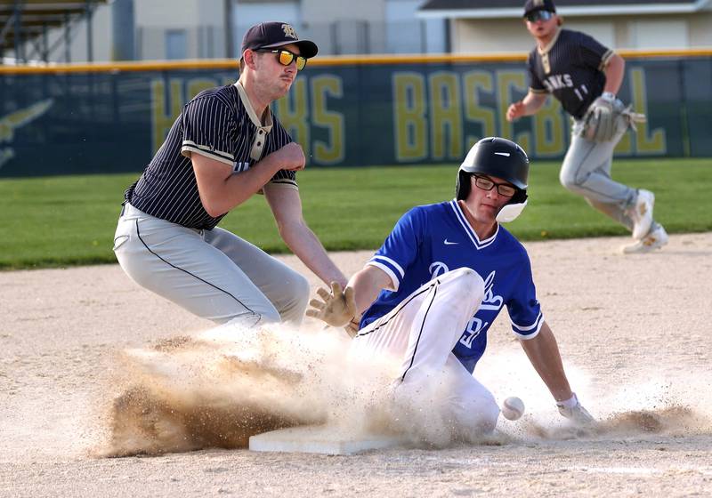 Hinckley-Big Rock's Marshall Ledbetter steals third as Hiawatha’s Aidan Cooper tries to dig out the low throw Tuesday, April 29, 2025, during their game at Hiawatha High School in Kirkland.