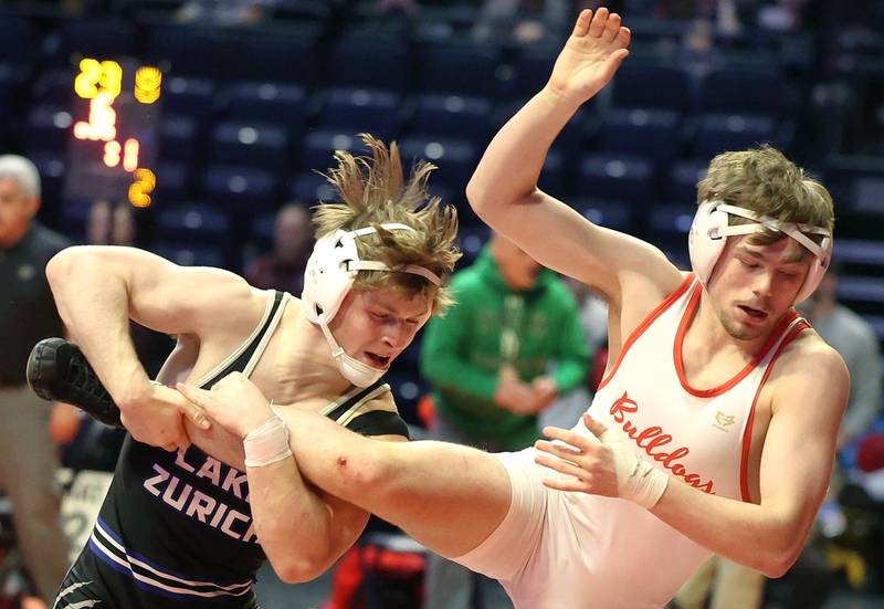 Batavia’s Cael Andrews (right) tries to keep his feet as Lake Zurich’s Scott Busse tries to bring him down during the Class 3A 145 pound 5th place match in the IHSA individual state wrestling finals in the State Farm Center at the University of Illinois in Champaign.