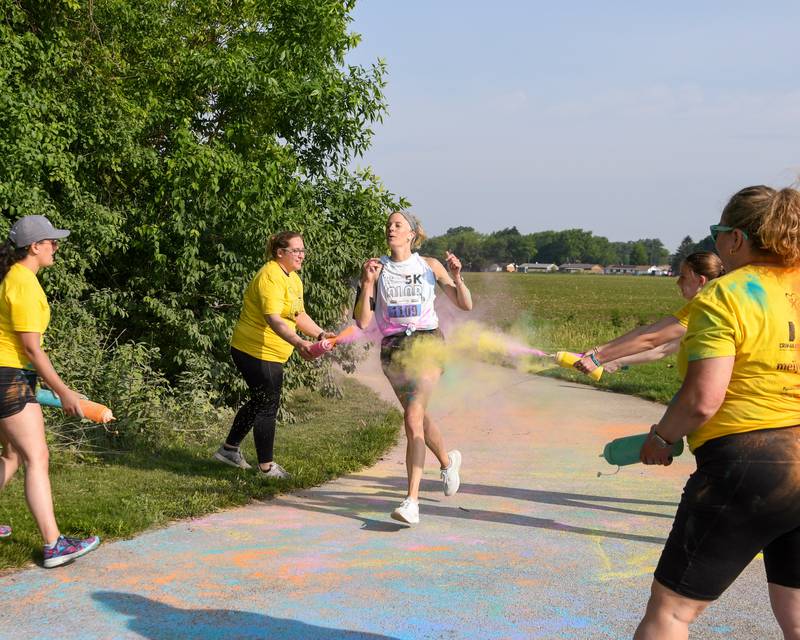 Laura Heitzig get sprayed with color powder on Saturday, June 7, 2025, during the CASA DeKalb County 5K Color Run held at the Sycamore Middle School.