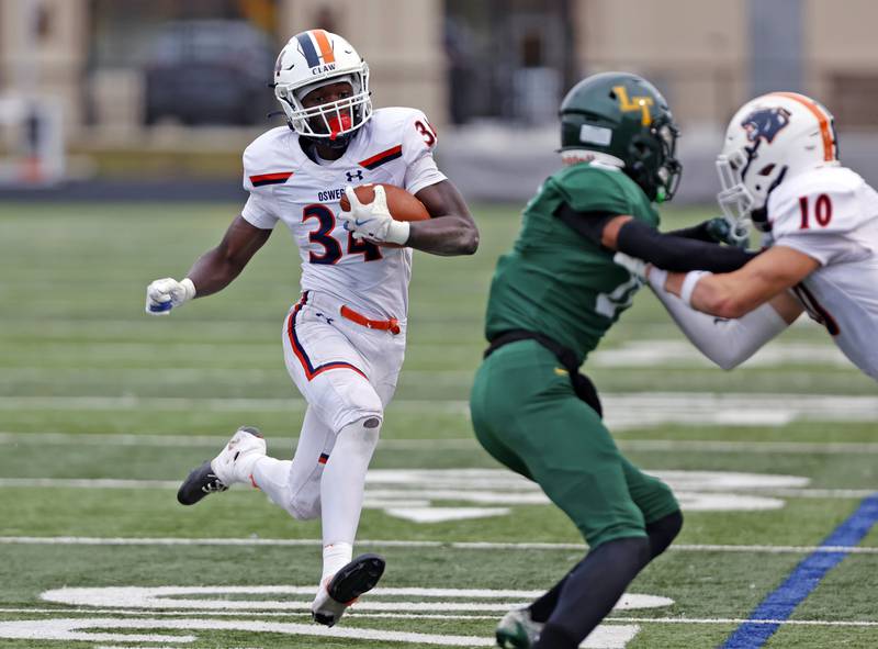Oswego's Ammar Banire (34) runs the ball during the varsity football second-round 8A playoff game between Oswego and Lane Tech on Saturday, Nov. 8, 2025 in Chicago.