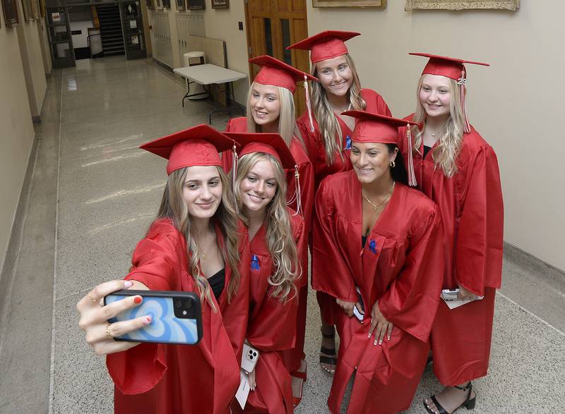 Before heading out to King Field six of the 321 graduates stop to capture the moment in the halls of Ottawa High School on Friday, May 26, 2023, during the graduation ceremony.