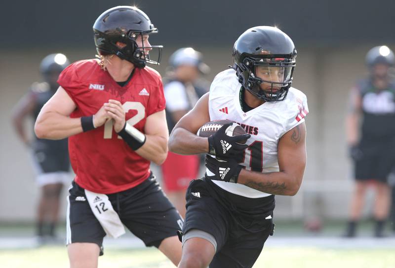 Northern Illinois Huskies running back Gavin Williams carries the ball after taking the handoff from quarterback Rocky Lombardi during the teams first practice of the season Wednesday, Aug. 2, 2023, at Huskie Stadium in DeKalb.