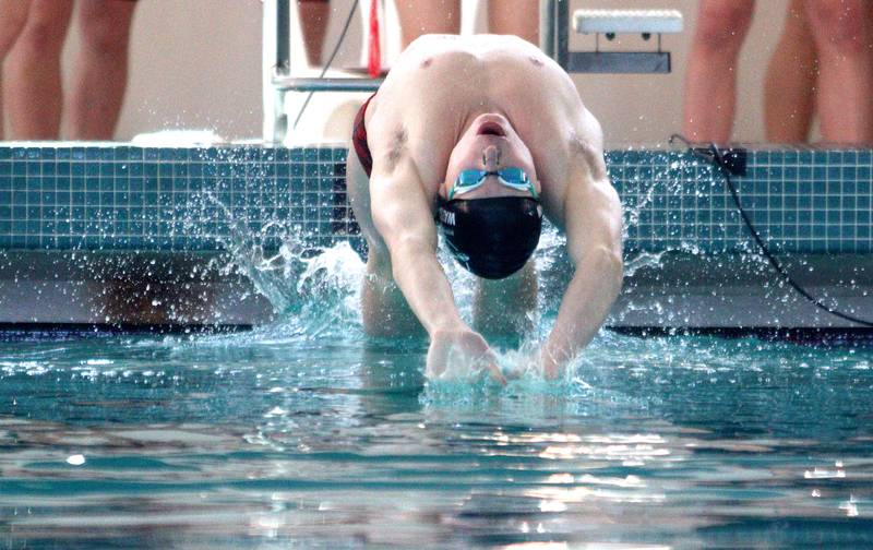 Cary-Grove’s Drew Watson launches at the start of the 100-yard backstroke at the Fox Valley Conference Boys Swimming Invite at Woodstock North on Saturday.
