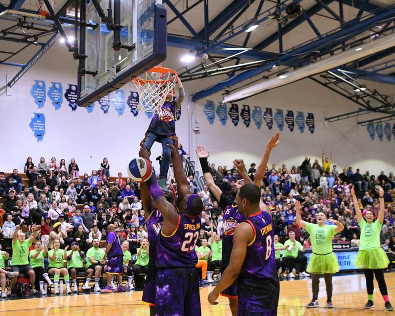 Andrew Lee,5, makes a basket with the assistance of the Harlem Wizards to run out the clock on Sunday Jan. 19, 2025, held at Downers Grove South High School.