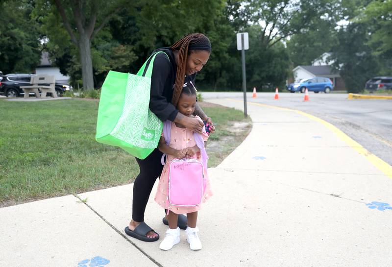 Brenda Boyd helps her daughter, Asantewaa Lumemba, 5, with her backpack before her first day of kindergarten at Wild Rose Elementary School in St. Charles on Monday, Aug. 14, 2023.