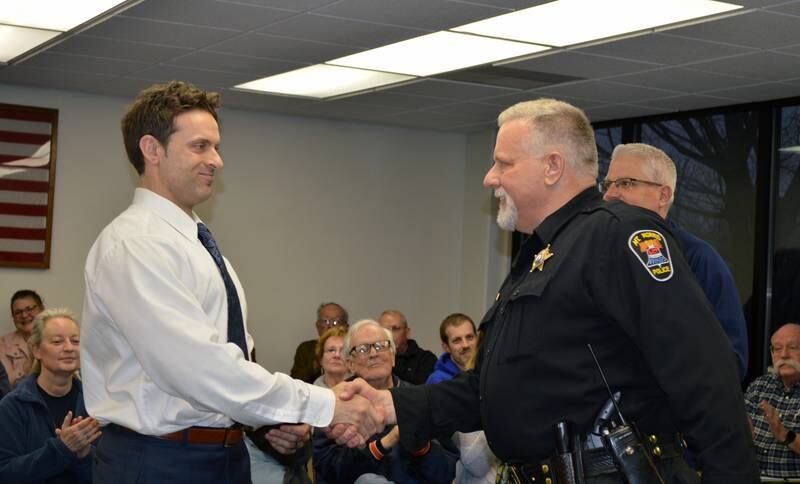 Mt. Morris Police Chief Michael Cicchetti, left, shakes hands with now former Chief Jason White after being sworn in during the April 12 village board meeting. White retired after 19 years as chief and 35 years with the Mt. Morris Police Department. Cicchetti entered law enforcement in 2008.