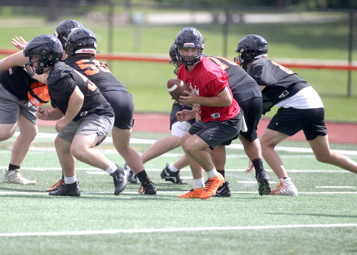 St. Charles East’s Mac Paul (center) plays quarterback during the first day of practice for the fall season on Monday, Aug. 7, 2023 at the school.