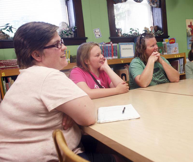 From left, Sara McAllister, Brooke Wackerlin and Amy Wackerlin listen as handwriting analyst Chris McBrien speaks at the Clinton Township Public Library