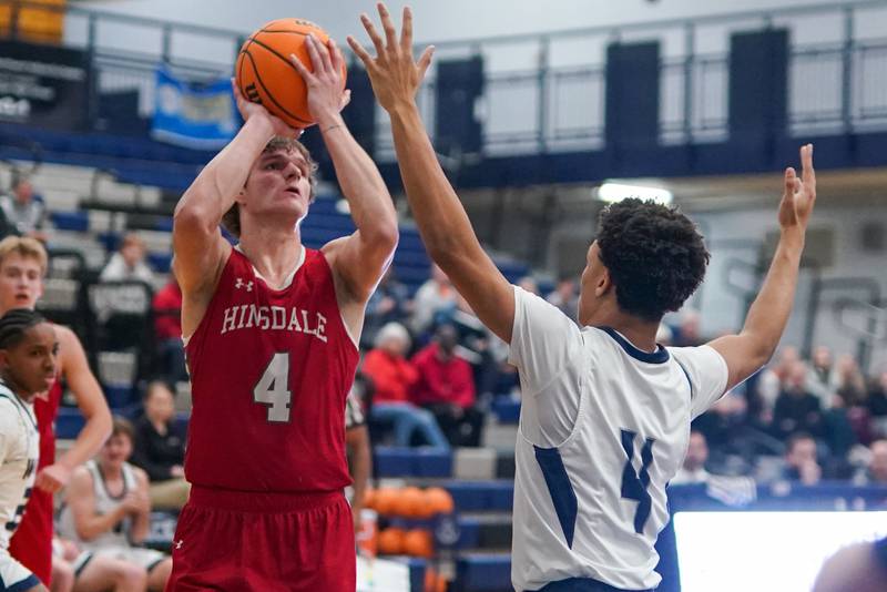 Hinsdale Central's Vincas Buzelis (4) shoots the ball in the post against Oswego East's Myles Buchanan (4) during a hoops for healing tournament basketball game at Oswego East High School on Tuesday, Nov. 26, 2024.