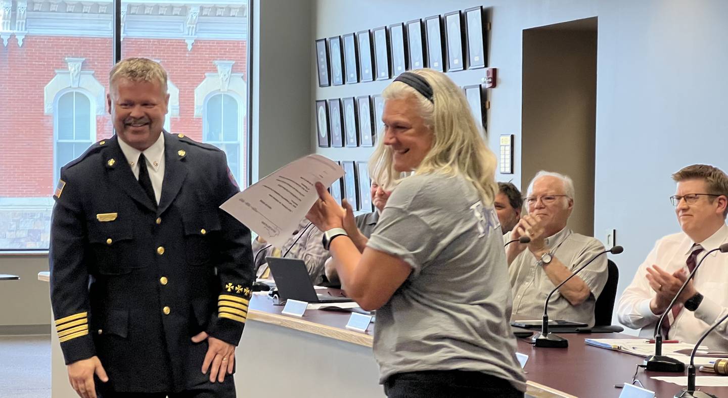 Sycamore Fire Chief Bart Gilmore – standing next to Sycamore City Clerk Mary Kalk – smiles while looking at his family moments after being sworn in as the city's new fire chief on June 5, 2023.