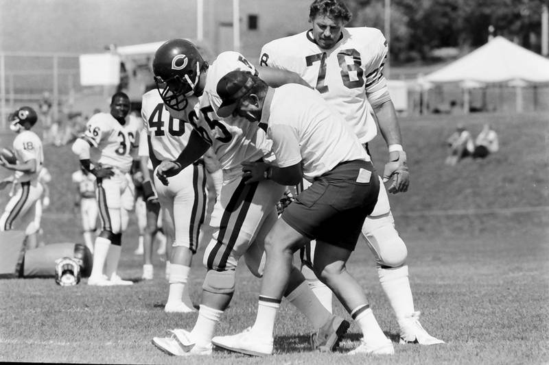 Chicago Bears player Eugene Rowell (65) and Keith Van Horn (78) work with offensive corrdinator Ed Hughes during training camp on Wednesday, June 12, 1985 in Platteville Wis.