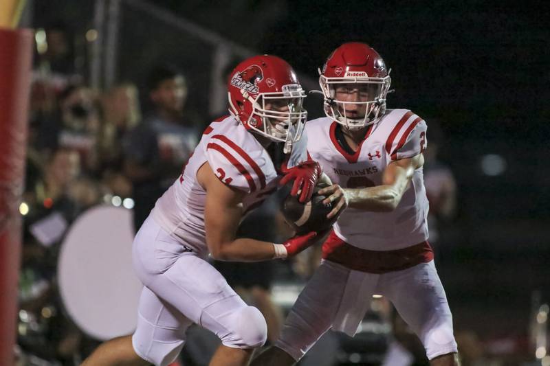 Naperville Central's Owen Prucha hands off to Tyler Dodd during football game between Hinsdale Central vs Naperville Central.  August 27, 2021.  Gary E Duncan Sr. for Shaw Local.