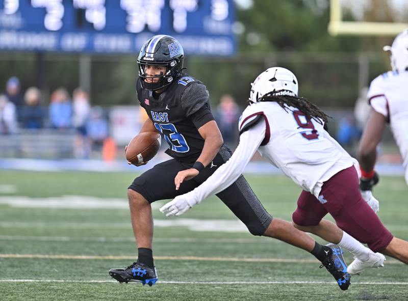Lincoln Way East's Jonas Williams (13) attempts to elude Kankakee's Dayshawn Brown (9) during the non-conference game on Friday, Sept. 05, 2025, at Frankfort.