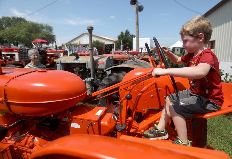 Sutton, of Marengo, pretends to drive a tractor as his grandmother watches during the opening day of the McHenry County Fair on Tuesday, July 29, 2025. The fair runs through Sunday at the fairgrounds in Woodstock.