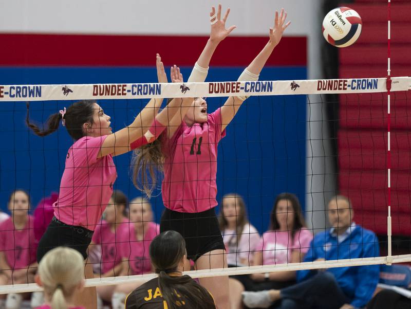 Dundee-Crown's Natalie Olsen, left, and Erin Bruce block a ball at the net during their game against Jacobs on Thursday, October 16, 2025 at Dundee-Crown High School in Carpentersville. Ryan Rayburn for Shaw Local