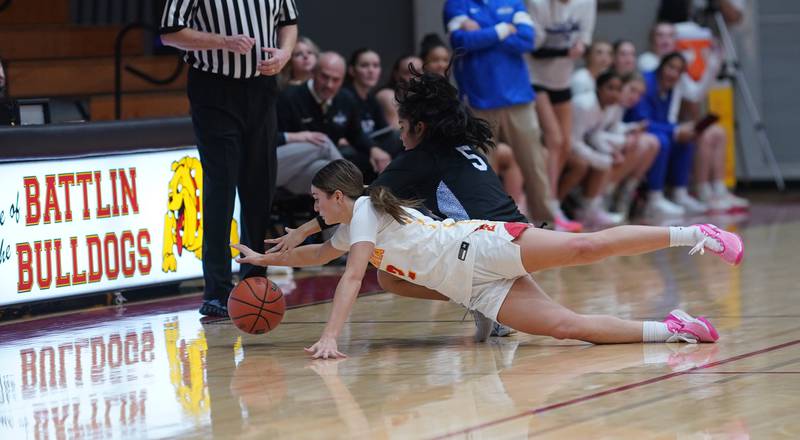 Batavia's Brooke Carlson (2) dives for a loose ball against St. Charles North's Sydney Johnson (5) during a basketball game at Batavia High School on Tuesday, Dec 5, 2023.