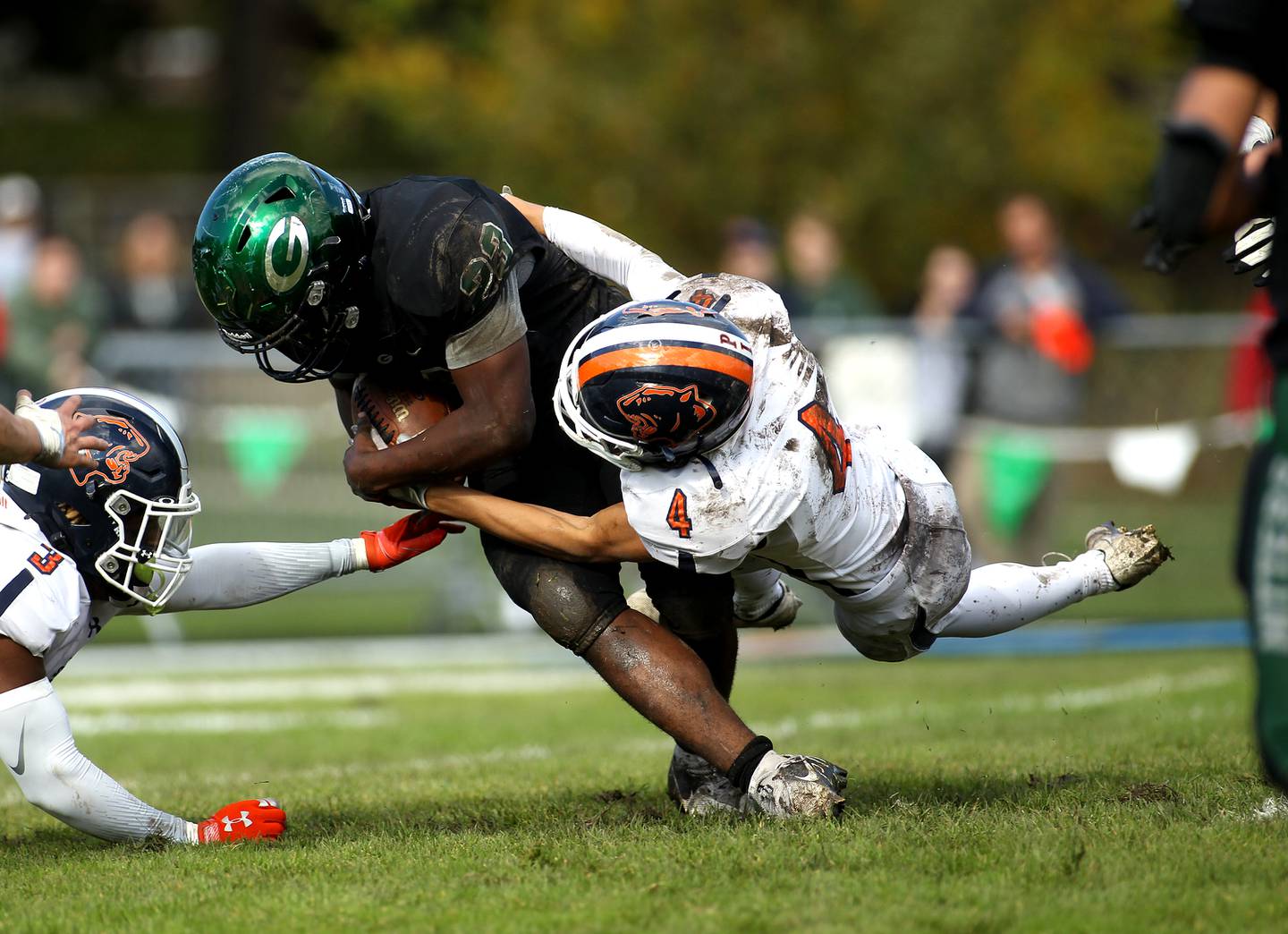 Glenbard West's Jason Thomas (23) is tackled by Oswego's Triston August (4) during a Class 8A playoffs first-round game in Glen Ellyn on Saturday, Oct. 30, 2021.
