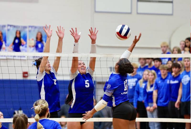 Newman's Giselle Martin takes a swing against Princeton's Keighley Davis (left) and Kelly Lawson (5). The Tigresses won 25-18, 25-16.