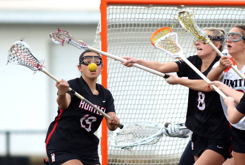 Huntley’s Ally Schneider, left, tries to corral the ball in varsity girls lacrosse on Friday, April 18, 2025, at Metcalf Field on the campus of Crystal Lake Central High School in Crystal Lake.