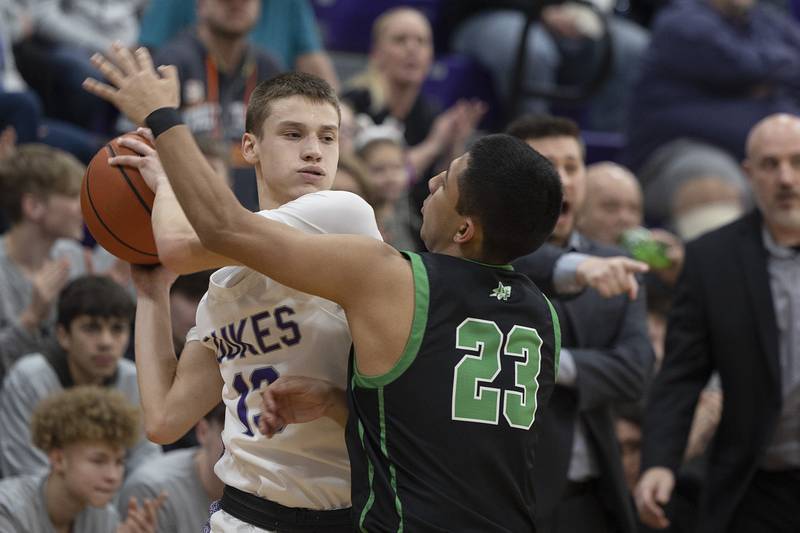 Dixon’s Cullen Shaner looks to pass while being guarded by Rock Falls’ Diego Hernandez Tuesday, Feb. 7, 2023.