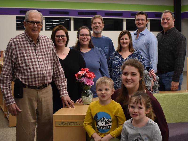 The Hartman family in front of the newly dedicated "Mrs. Hartman's Reading Really Matters Bookshelf."