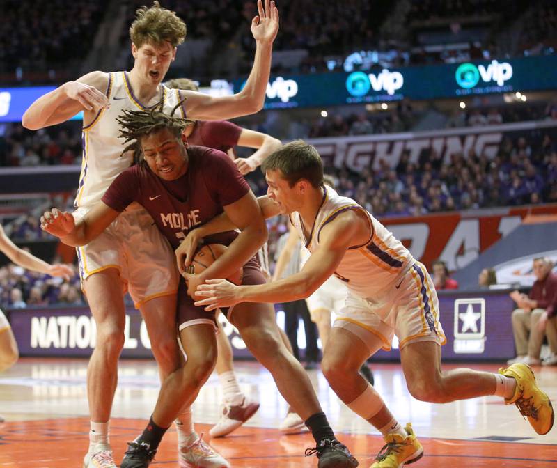 Moline's Treyvon Taylor takes the ball away from Downers Grove North's Jacob Bozemman as teammate Jake Reimer runs in from behind during the Class 4A state semifinal game on Friday, March 10, 2023 in Champaign.