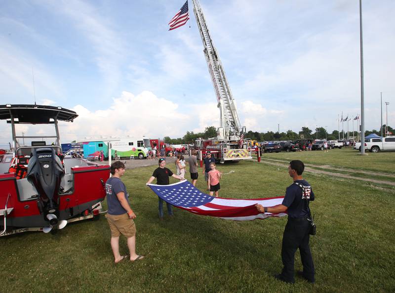 Members from the Spring Valley Fire Department fold up the American Flag during the Illinois Valley Pistol Shrimp First Responder Night on Tuesday, June 17, 2025 at Schweickert Stadium in Peru.