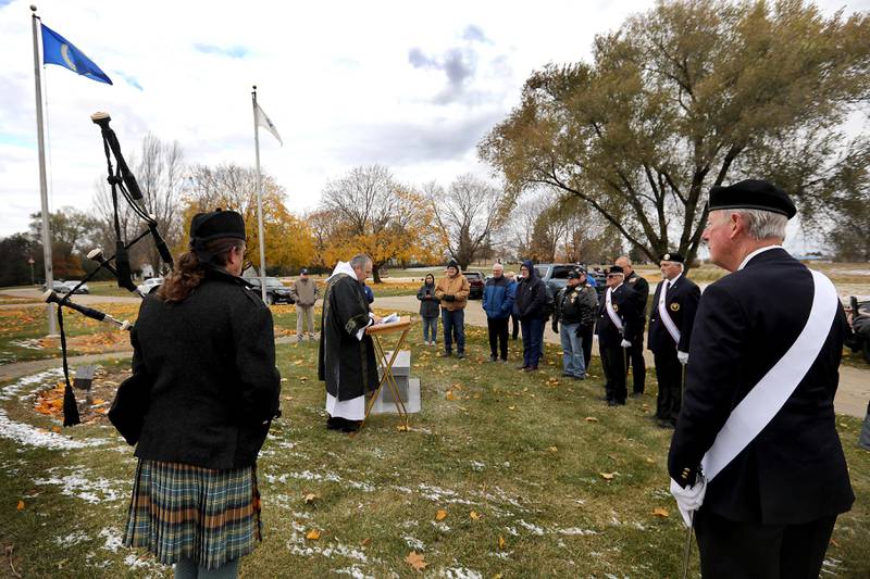 Deacon Ken Giacone, from St. Elizabeth Ann Seton Catholic Church in Crystal Lake, speaks during the Veterans Day flag placement ceremony Tuesday, Nov. 11, 2025, at the gravesites of veterans at McHenry County Memorial Park Cemetery in Woodstock. Members of the Knights of Columbus Patriotic 4th Degree from the Bishop Boylan Assembly placed American Flags at nearly 140 veterans' grave markers.