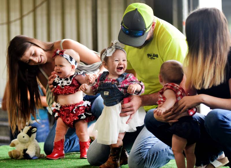 Parents show off candidates for Lil' Miss Barnyard during the Barnyard Baby Contest on July 16 at the Jasper County Fair.