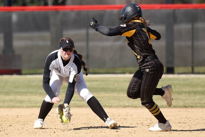 Bradley-Bourbonnais' Liv Woolman, left, fields a ground ball and looks to tag out Herscher's Abby Overacker during a game at Bradley-Bourbonnais Monday, March, 24, 2025.